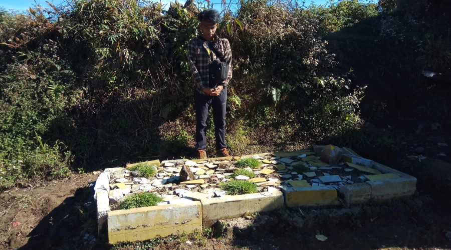 berfoto di depan makam di puncak gunung salak
